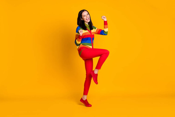 Full body photo of happy smile positive girl celebrate win victory fists hands yell yes isolated over yellow color background - Fotó, kép
