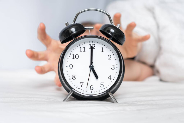 Женщина с будильником в шоке колокол, не хочет просыпаться рано - Фото, изображение