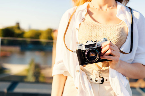 Молода жінка тримає камеру під час літньої подорожі
. - Фото, зображення