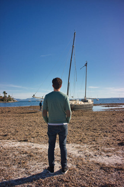 vene rannalla miehen kanssa takaapäin - Valokuva, kuva