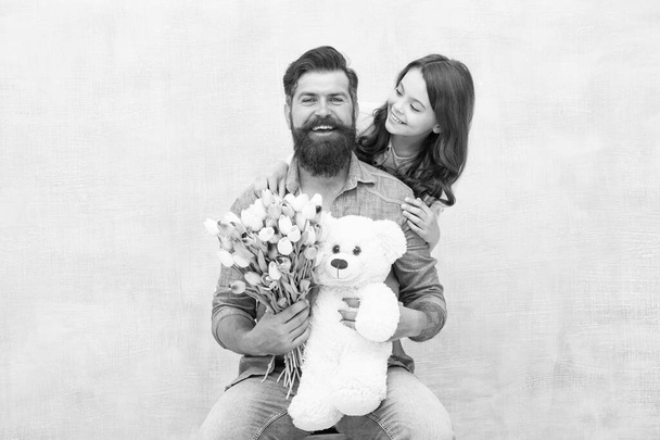 Heres to celebrating you. Happy family celebrate birthday. Little girl congratulate bearded man. Small daughter and father hold flowers and toy. Birthday anniversary. Happy birthday to you - Photo, Image