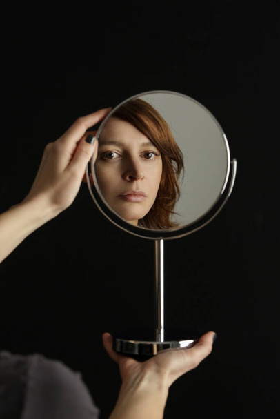 Mirror reflection of a woman's face, studio shot - Valokuva, kuva