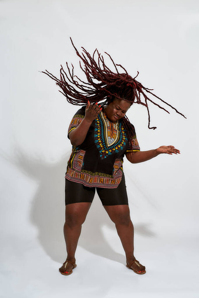 Plump african american woman shaking long dreadlocks - Foto, Imagem