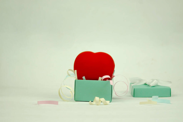 Corazón rojo en caja de regalo azul con papel rallado, dando amor como regalo en el concepto del día de San Valentín - Foto, imagen