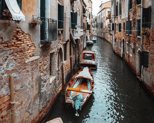 Вузький канал з човнами між старими будинками Венеції (Італія). - Фото, зображення