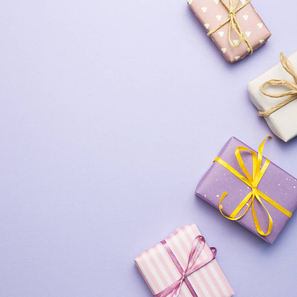 Purple gift boxes on purple background. flat lay, top view, copy space - 写真・画像