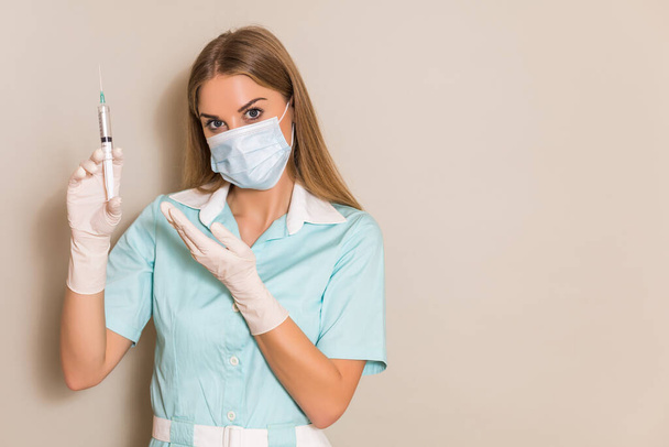 Portrait of nurse with protective mask holding injection. - Foto, Imagem