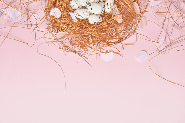 Quail eggs in nest on pink background. Easter minimal creative horizontal composition with copy space. Spring Happy Easter holiday Greeting card. Top view. - Foto, immagini