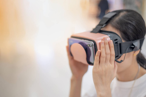 Egy nő virtuális valóság szemüveget visel a modern belsőépítészeti coworking stúdióban. Okostelefon VR fejhallgatóval. Új innováció a 3D design, érzés 360 fok a szobában. - Fotó, kép