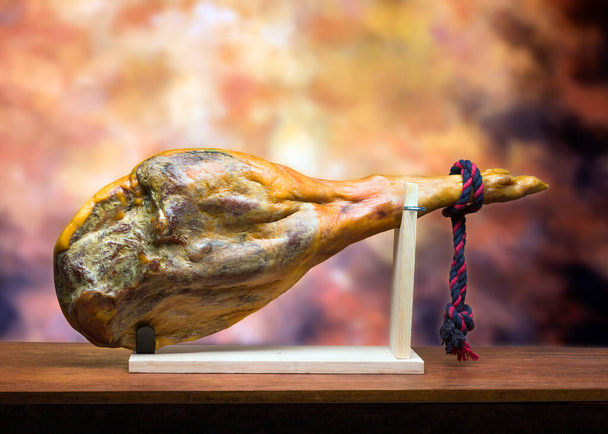 Hamon - πόδι αποξηραμένου χοιρινού κρέατος - σε ξύλινη βάση. - Φωτογραφία, εικόνα