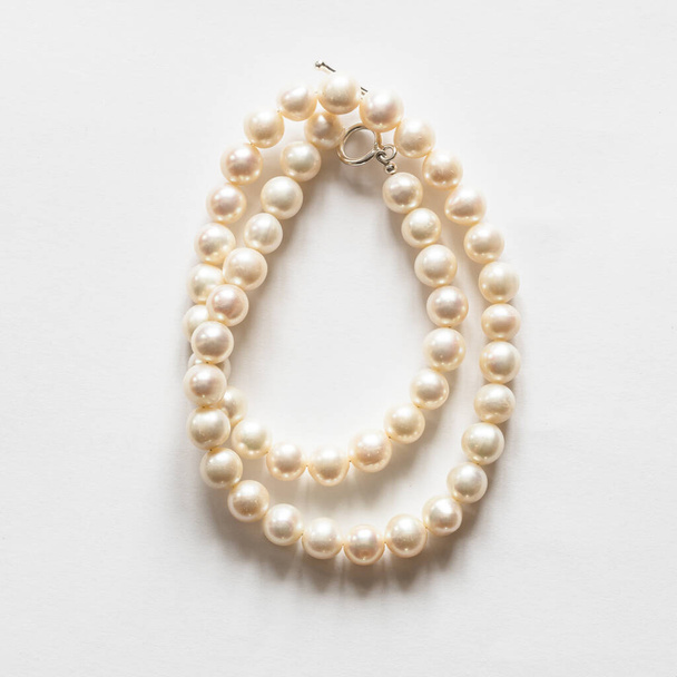 collier naturel plié en perles blanches sur fond blanc - Photo, image