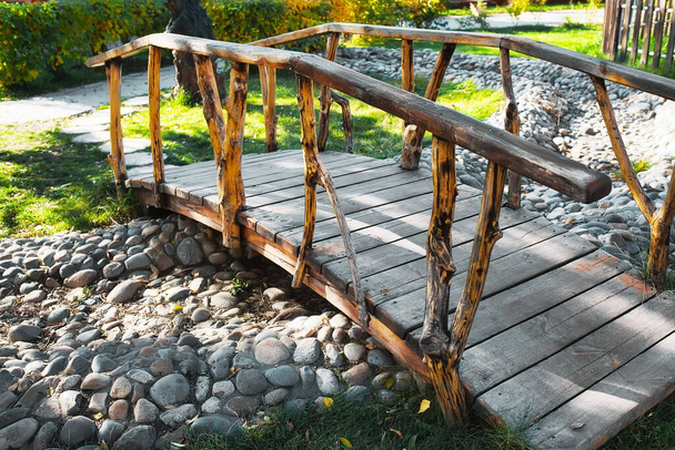 Pont en bois vintage dans un parc d'été à travers un ruisseau asséché.  - Photo, image