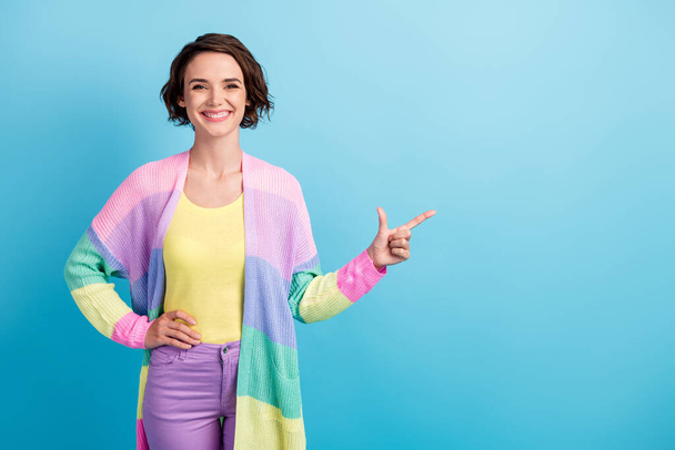 Photo portrait of smiling woman pointing finger at blanks space isolated on pastel blue colored background - Fotografie, Obrázek