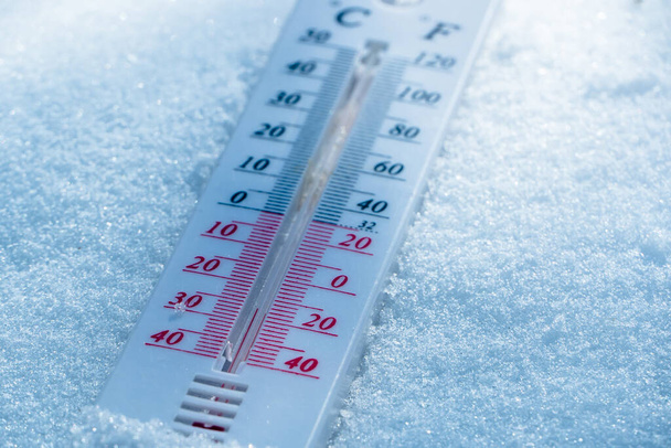 De thermometer ligt 's winters op de sneeuw met een negatieve temperatuur. Meteorologische omstandigheden in een hard klimaat in de winter met lage lucht- en omgevingstemperatuur.Bevriezen in de winter - Foto, afbeelding