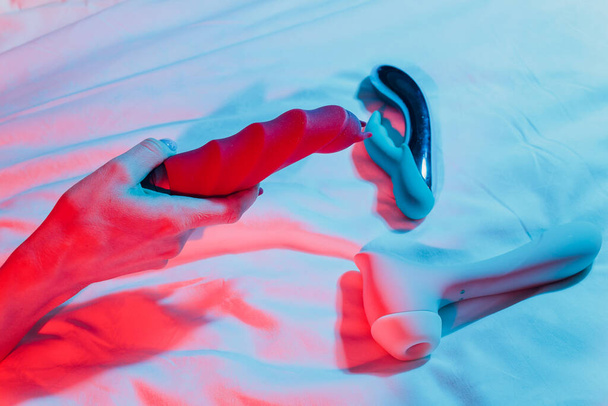 Woman in bedroom holding vibrator in hand. - Foto, Imagem