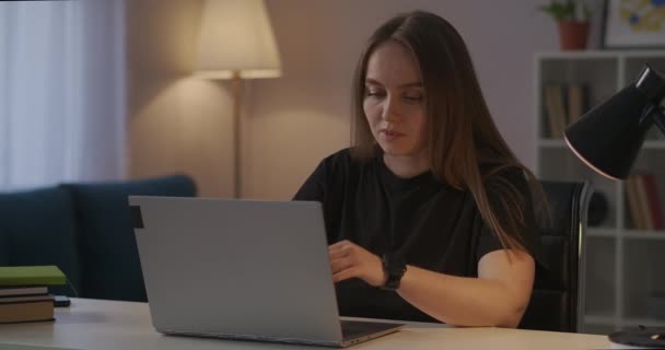 mujer sobrecargada de trabajo está frotando las sienes durante el trabajo con el ordenador portátil en casa por la noche, dolor de cabeza y fatiga excesiva - Imágenes, Vídeo