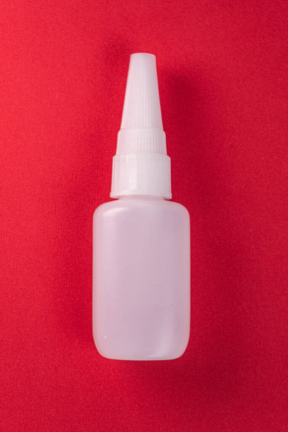 Glue bottle on the colorful background - Foto, afbeelding