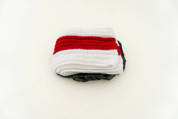 Sciarpa lavorata a maglia bianca rossa bianca giace sulla neve - Foto, immagini