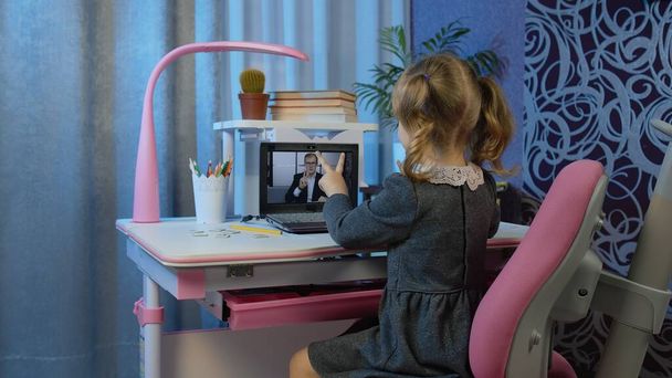 Νηπιαγωγείο κορίτσι απόσταση online εκπαίδευση στο σπίτι, μαθητής βλέποντας μαθήματα βίντεο στο φορητό υπολογιστή - Φωτογραφία, εικόνα
