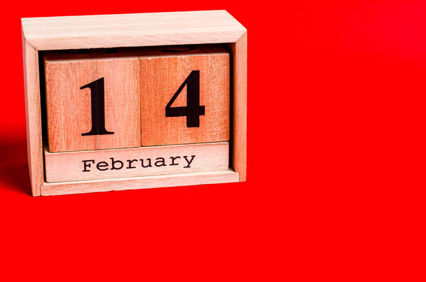 Деревянный календарь с 14 февраля на красном фоне. Концепция любви, пространство для копирования, плоская кладка, место для текста, баннер, вид сверху. - Фото, изображение
