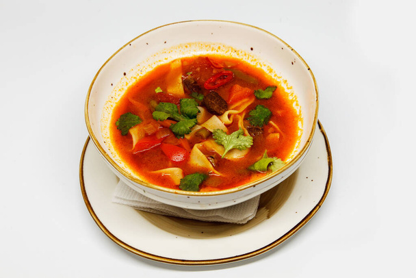 Spicy soup in a deep plate on a white background - Foto, immagini