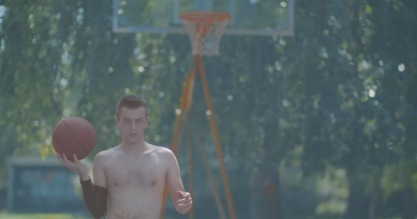 Weteran koszykarz odbijając i obracając piłkę przed grą - Materiał filmowy, wideo