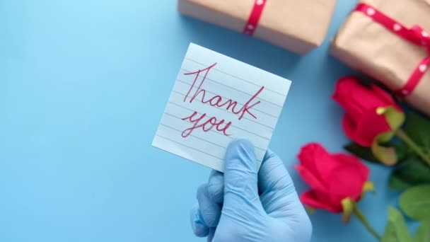 person hand in protective gloves holding thank you letter  - Footage, Video