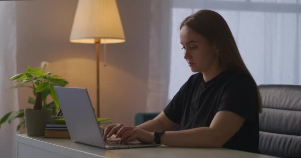 jonge vrouw werkt met laptop en voelt plotselinge hoofdpijn tijdens het werk, vermoeidheid en overwerk van kantoormedewerkers en freelancers - Video