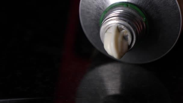 Detailweergave van mayonaise die uit een aluminium buis stroomt, geïsoleerde achtergrond. - Video