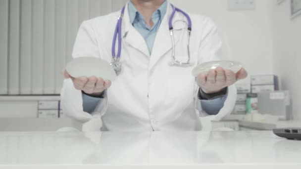 Chirurgien plastique tenant des implants mammaires en silicone à la caméra - Séquence, vidéo