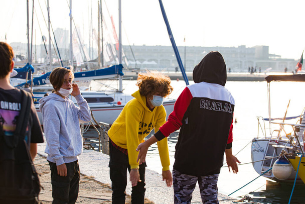 Trieste, Italia - 10 de octubre: Niños jugando a aplaudir al lado del mar el 10 de octubre de 2020 - Foto, imagen