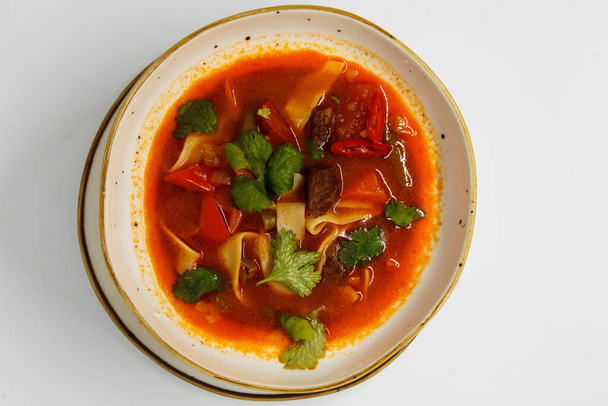 Spicy soup in a deep plate on a white background - Photo, Image
