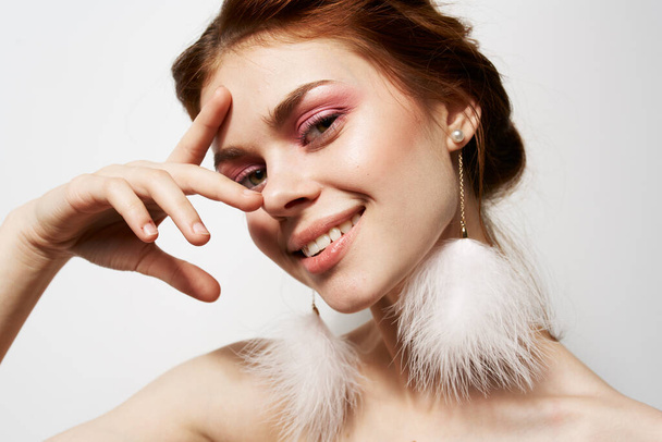 cheerful woman naked shoulders fluffy earrings bright makeup closeup - Photo, Image