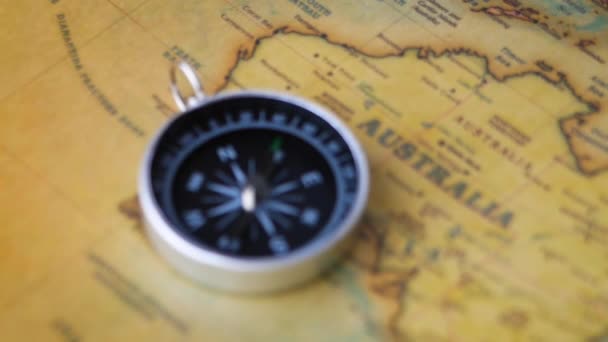 Close-up van een draaiend vintage kompas op de oude kaart. Begrippen "reizen" en "navigatiemiddel". - Video