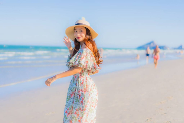 Retrato hermosa joven asiática mujer feliz sonrisa relajarse alrededor tropical playa mar océano en azul cielo para el ocio - Foto, imagen