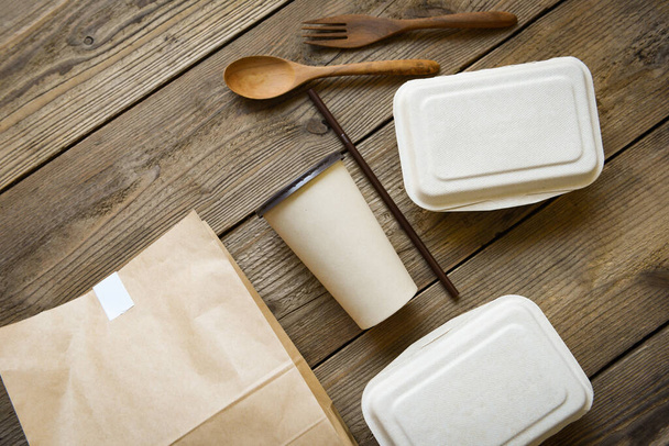 Kertakäyttöiset ympäristöystävälliset pakkausastiat, joissa on paperimuki ja käsityöpaperiruoka puupöydällä kotona, Huolto elintarvikkeiden tilaus online-toimitus ruoka laatikko vie laatikot - Valokuva, kuva