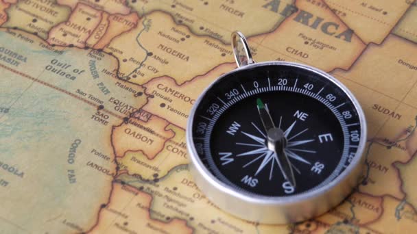 Zblízka záběr točícího se retro kompasu na starobylé mapě. Pojmy cestování a navigační nástroj. - Záběry, video