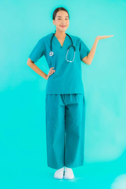 Retrato hermosa joven asiática médico mujer feliz sonrisa para el trabajo en hospital y clínica en azul aislado fondo
 - Foto, imagen