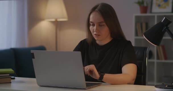 Frau arbeitet zu Hause mit Laptop, spürt Müdigkeit und Schmerzen in Kopf und Nacken, schließt Notizbuch und entspannt - Filmmaterial, Video