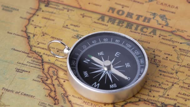 Közelkép egy forgó vintage iránytűről az ősi térképen. Utazási fogalmak és navigációs eszközök. - Felvétel, videó