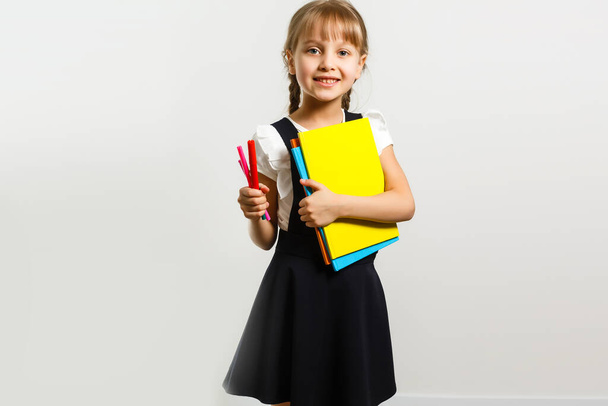 mała blondynka szkoła dziewczyna z plecakiem torba portret izolowany na białym tle - Zdjęcie, obraz