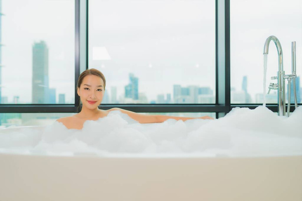 Retrato bonito jovem asiático mulher relaxar sorriso lazer na banheira no banheiro interior - Foto, Imagem