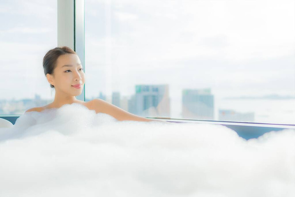 Портрет красивая молодая азиатская женщина расслабиться насладиться ванной в ванной комнате интерьера - Фото, изображение