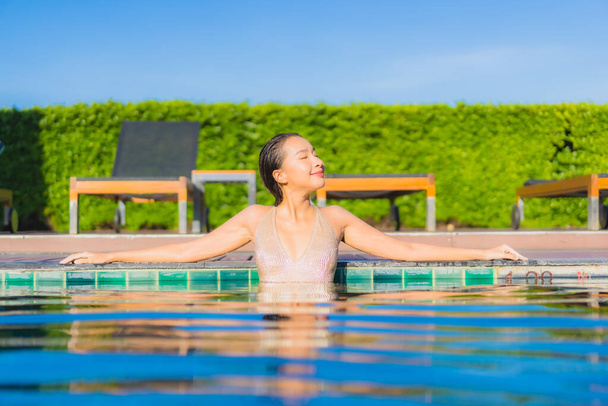 portrét krásná mladá asijka relax úsměv volný čas kolem venkovního bazénu v hotelovém resortu - Fotografie, Obrázek