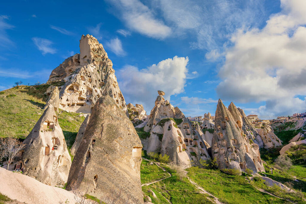 Landscape mountain of cappadocia in Turkey. Sharp sandstone mountain The villagers use it as a house and have many windows. In the summer there are green grass and blue skies. - Foto, imagen