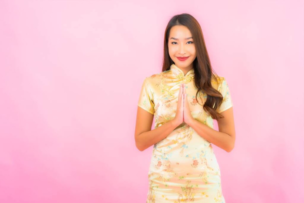 Portrait beautiful young asian woman with red envelopes in chinese new year concept on pink background - Zdjęcie, obraz