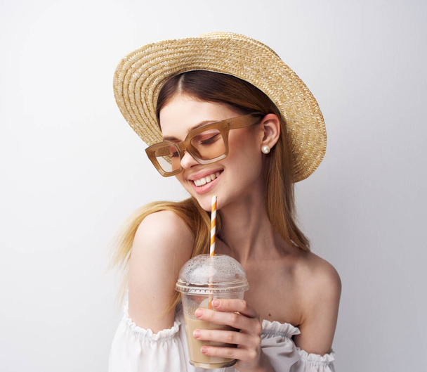 Beautiful woman with glasses hat on her head fashion fun drink in her hands - Photo, Image