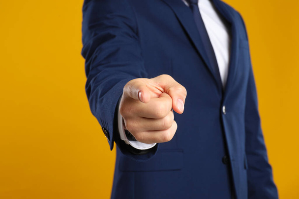 Businessman touching something on yellow background, closeup. Finger gesture - Foto, afbeelding