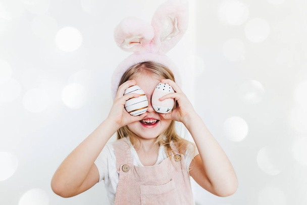 Little girl with Easter eggs and bunny ears hat - Fotoğraf, Görsel