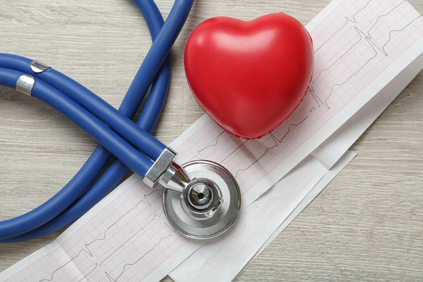 Cardiogram report, red heart and stethoscope on wooden table, flat lay - Fotoğraf, Görsel